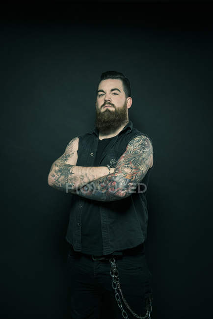 Man with folded tattooed arms — Stock Photo