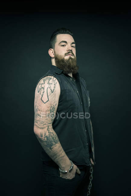 Man with tattooed arms in pockets — Stock Photo