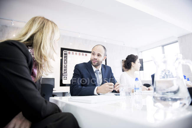 Люди, сидящие в офисной среде и обсуждающие — стоковое фото