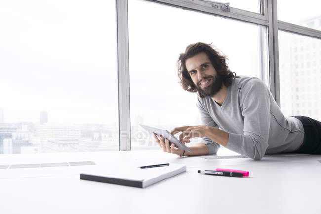 Hombre haciendo notas en el ordenador tableta - foto de stock