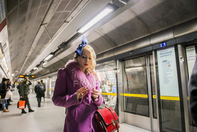 Woman standing on tube platform — Stock Photo