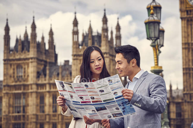 Couple looking into city guide — Stock Photo