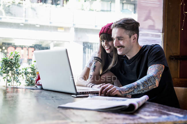 Casal trabalhando no laptop no café — Fotografia de Stock