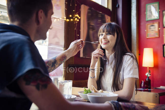 Пара наслаждается едой в кафе — стоковое фото
