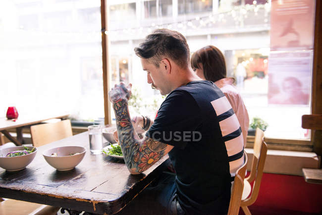 Coppia godendo pasto in caffetteria — Foto stock