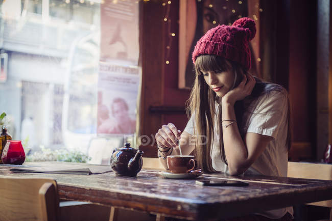 Donna seduta a tavola in caffetteria — Foto stock