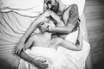 Tenera coppia che abbraccia a letto — Foto stock