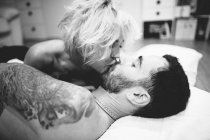 Paar küsst sich im Bett — Stockfoto