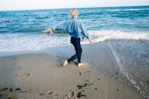 Chica descalza en la orilla del mar - foto de stock