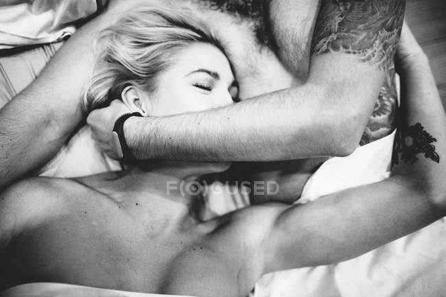 Concurso casal abraçando na cama — Fotografia de Stock