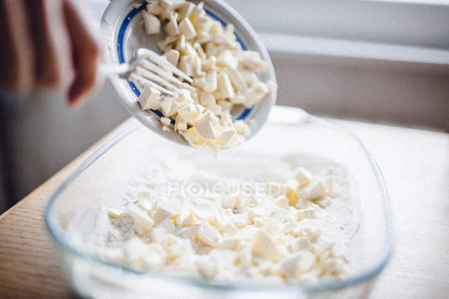 Mettre le beurre à la main sur une plaque à pâtisserie — Photo de stock