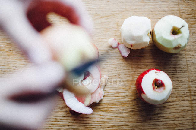 Mãos humanas esfolar maçãs — Fotografia de Stock