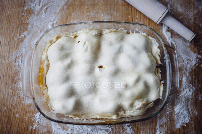 Pie covered by dough in baking tray — Stock Photo