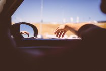 Man leaning hand out of car window — Stock Photo