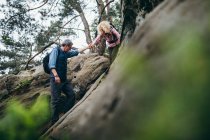 Paar wandert auf Felsen im Wald — Stockfoto
