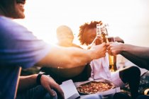 Friends enjoying drinks and pizza — Stock Photo