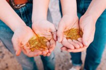 Mani femminili in possesso di glitter dorati — Foto stock
