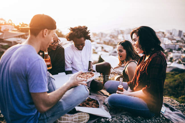 Друзья наслаждаются напитками и пиццей — стоковое фото