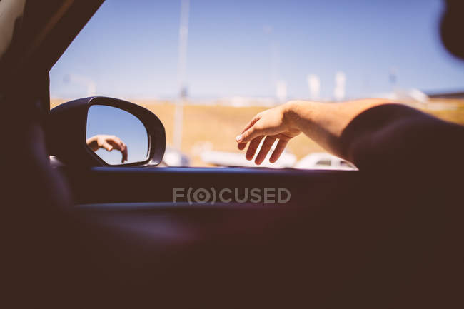 Мужчина, высунувший руку из окна машины — стоковое фото