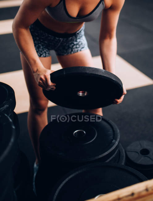 Femme soulevant des poids dans la salle de gym — Photo de stock
