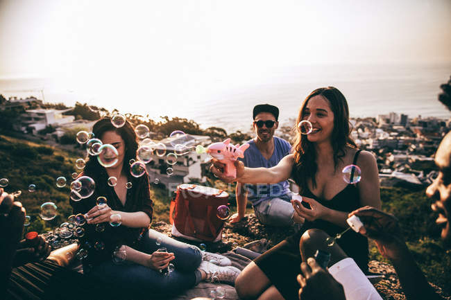 Friends having fun with blowing bubbles — Stock Photo