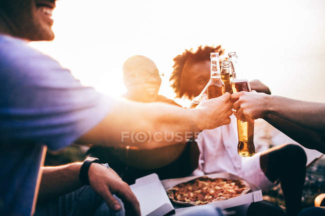 Friends enjoying drinks and pizza — Stock Photo
