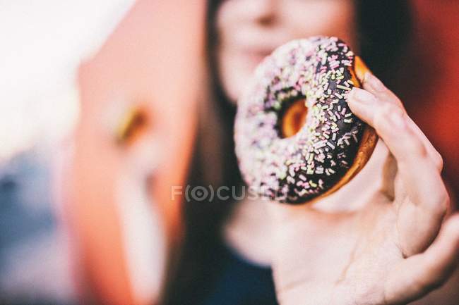 Woman holding chocolate donut — Stock Photo