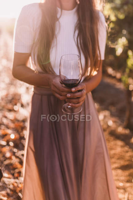 Woman standing and holding wine glass — Stock Photo