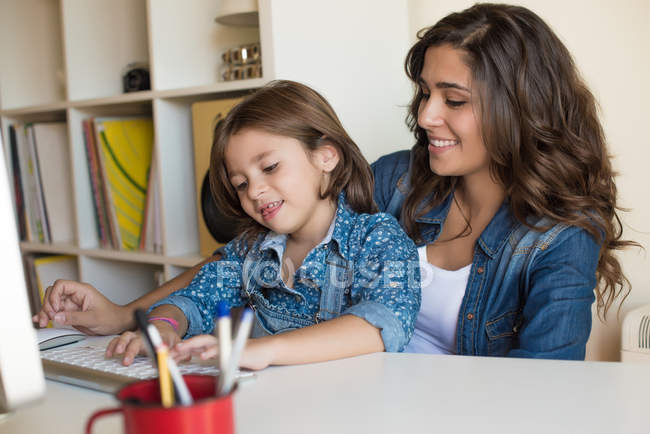 Donna con ragazza utilizzando il computer — Foto stock