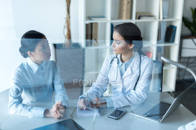 Médico conversando com paciente no consultório — Fotografia de Stock