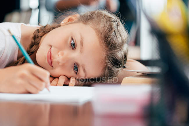 Маленькая девочка пишет домашнее задание — стоковое фото