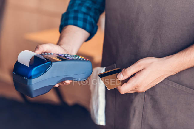 Бариста с кредитной картой и кард-ридером — стоковое фото