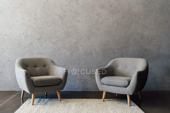 Fauteuils gris sur tapis — Photo de stock