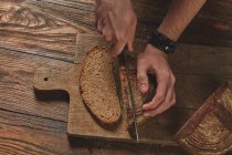 Baker cutting bread — Stock Photo
