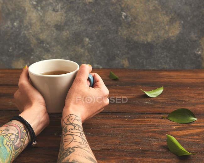 Mulher segurando xícara quente de chá — Fotografia de Stock