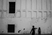 Дети играют против стены — стоковое фото
