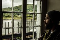 Mann blickt auf Fenster mit malerischem Blick — Stockfoto