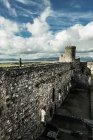 Mann steht auf Ruinen einer verwitterten Burg — Stockfoto
