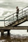Uomo in piedi sulle scale al molo — Foto stock