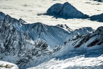 Picos de montaña en cubierta de nubes - foto de stock