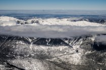 Berggipfel in der Wolkendecke — Stockfoto