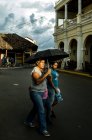 Жінки з дитиною, що йде по вулиці з парасолькою — стокове фото