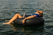 Жінка розслабляється на плавальному кільці — стокове фото