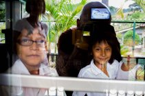 Счастливые дети, фотографируйтесь через окно — стоковое фото