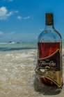 Garrafa de rum na praia — Fotografia de Stock