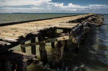 Кинутих pier з тіла місто на горизонті — стокове фото