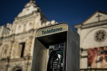 Street telephone with church in background — Stock Photo