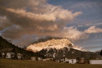 Dorf unter schneebedeckten Bergspitzen — Stockfoto