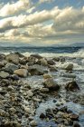 Хвилі розбиваються на камені на березі моря — стокове фото