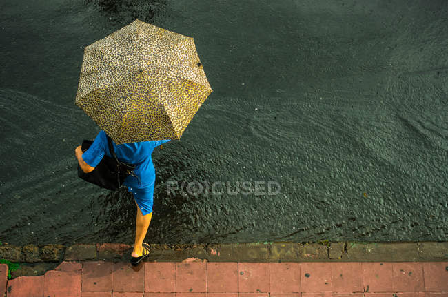 Woman jumping over puddle — Stock Photo